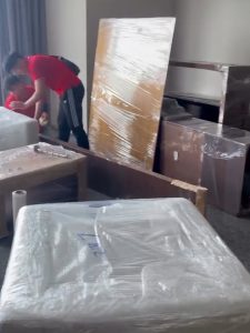 Kỹ thuật viên Thành Hưng đang quấn màng PE bảo vệ tủ gỗ